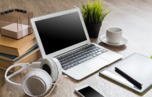 Laptop phone headphones and coffee on a desk