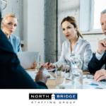 Three recruiters listen seriously during a panel interview for red and green flags.