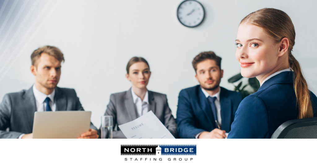 Job applicant sits in front of a panel of interviewers holding a resume