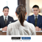 Job applicant viewed from behind sits facing two interviewers