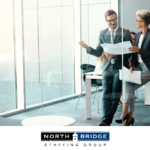 Two professionals discuss papers in an office, illustrating successful relationship-first recruiters.