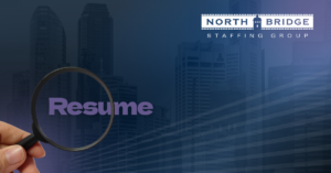 A magnifying glass is held over the word "Resume," illustrating how to build a resume that gets recruiter attention.
