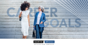 Two professional women walking and talking on steps with the words Career Goals displayed in the background