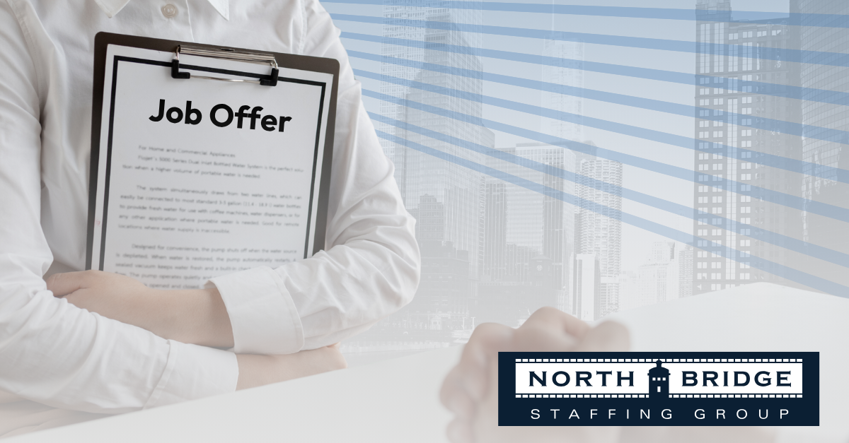 An applicant in an interview holds a clipboard containing a paper labeled "job offer".