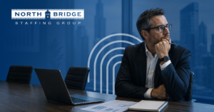 An employer sits at a laptop looking thoughtfully into the distance, considering the cost of dormant roles on the organization.